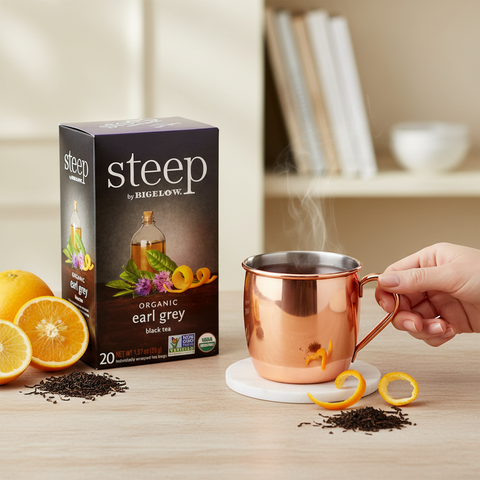 Bean Here Bean There Coffee & Cocoa Steep by Bigelow organic Earl Grey tea box next to a steaming copper mug