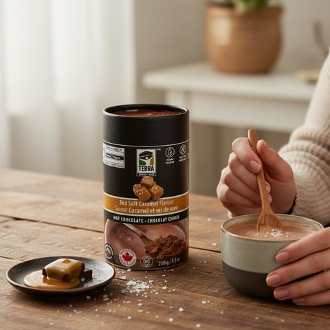 Bean Here Bean There Coffee & Cocoa Terra Sea Salt Caramel hot chocolate canister with a cup of cocoa on a table.