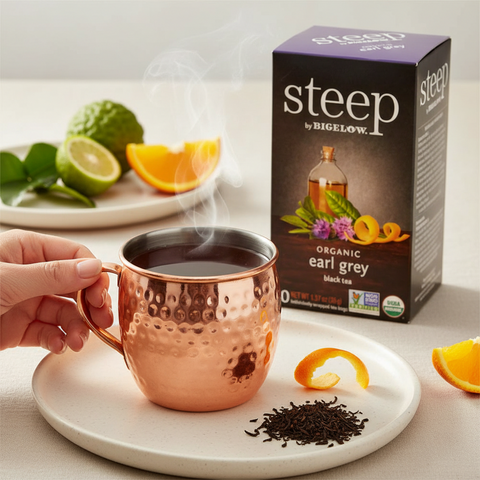 Bean Here Bean There Coffee & Cocoa Steep by Bigelow organic Earl Grey tea in a hammered copper mug with citrus